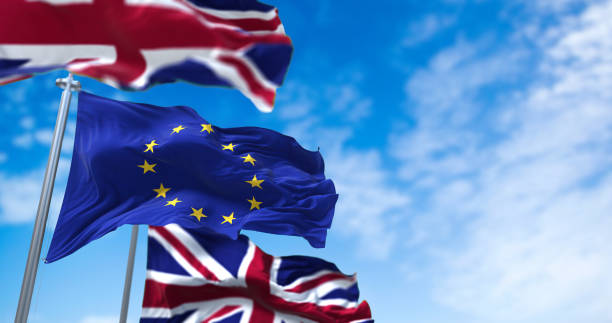 the flag of the european union waving between two flags of united kingdom with clear sky on the background - british flag freedom photography english flag imagens e fotografias de stock