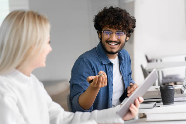 istock Cheerful male and female colleagues enjoying working process and cooperation 1352073838