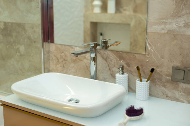 istock Modern bathroom in beige tones with marble tiles and white sink. Interior Design. Soft selective focus, art noise 1352073858