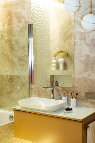 istock Modern bathroom in beige tones with marble tiles and white sink. Interior Design. Soft selective focus, art noise 1352073864