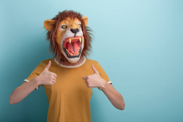 istock Young woman in lion mask keeps thumb up approval gesture 1352074402