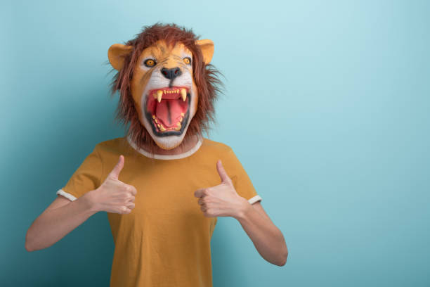 istock Young woman in lion mask keeps thumb up approval gesture 1352074461
