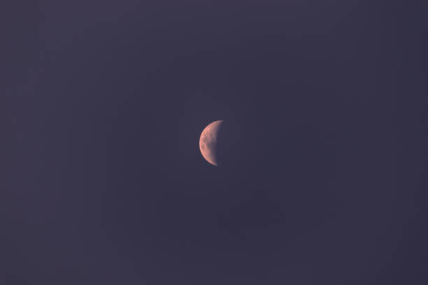 istock distant crescent moon in the southern hemisphere, floating in a blue sky covered by a fine mist. 1352075683