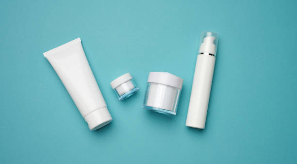istock jar, bottle and empty white plastic tubes for cosmetics on a blue background. Packaging for cream, gel, serum, advertising and product promotion 1352076024