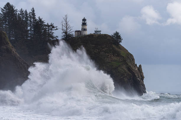 istock Large storm waves crashing under light house 1352077185