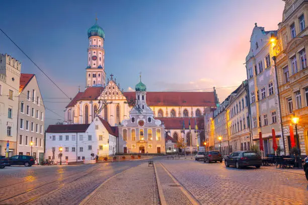 Cityscape image of old town street of Augsburg, Germany with the Basilica of St. Ulrich and Afra at autumn sunset.
