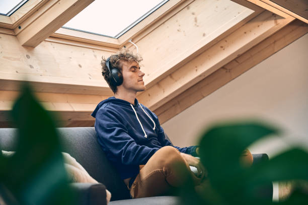 istock Young man relaxes in brightly lit, modern apartment 1352078267
