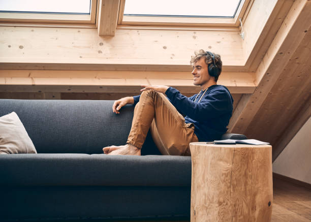 istock Young man relaxes in brightly lit, modern apartment 1352078278