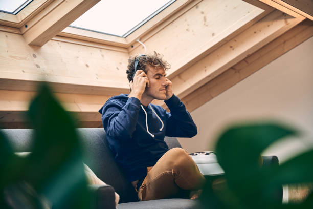 istock Young man relaxes in brightly lit, modern apartment 1352078287