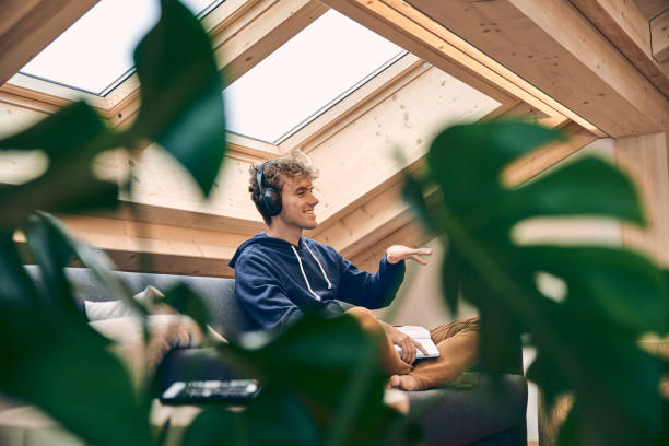 Young man relaxes in brightly lit, modern apartment