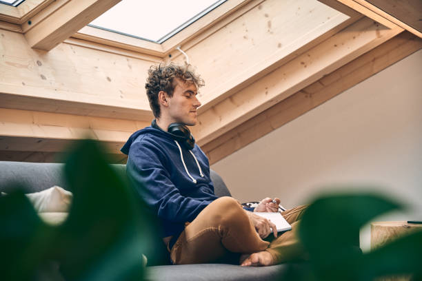 istock Young man relaxes in brightly lit, modern apartment 1352078301