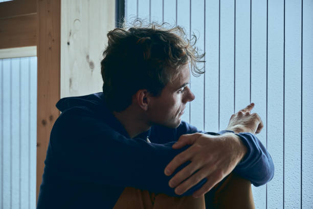 istock View of young man relaxing by window, in thought 1352078319