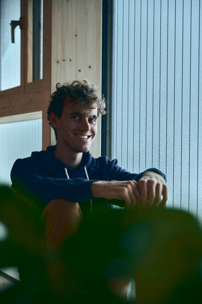 istock View of young man relaxing by window, in thought 1352078320