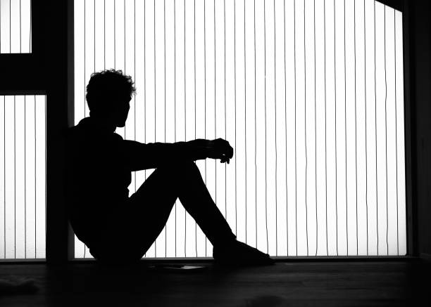 istock View of young man relaxing by window, in silhouette 1352078342