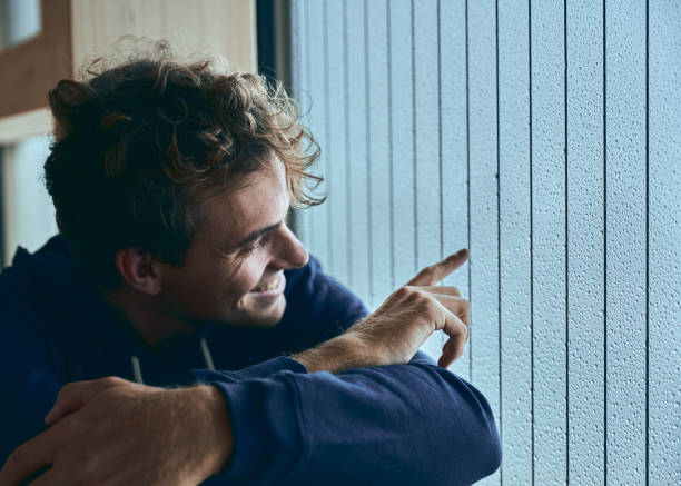 istock View of young man relaxing by window, in thought 1352078357