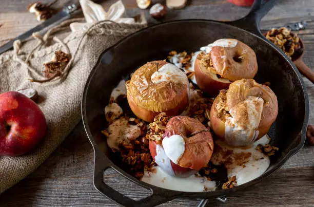 Delicious healthy and warm breakfast for autumn and winter season with stuffed baked apples. Filled with homemade granola or muesli and topped with yogurt.