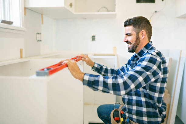 istock Concentrated young man work with white cabinet in the kitchen with level 1352080042