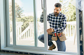 istock handsome young man installing bay window in a new house construction site 1352080264