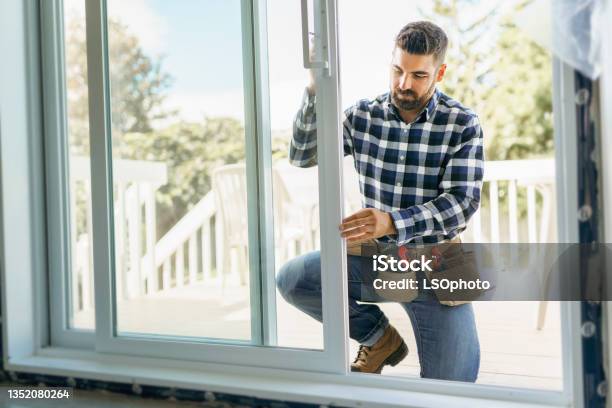 Handsome Young Man Installing Bay Window In A New House Construction Site Stock Photo - Download Image Now