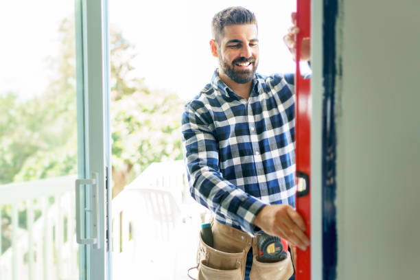 istock handsome young man installing bay window in a new house construction site with level 1352080345