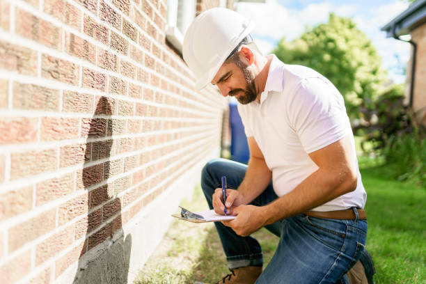 istock man with a white hard hat holding a clipboard, inspect house 1352080563