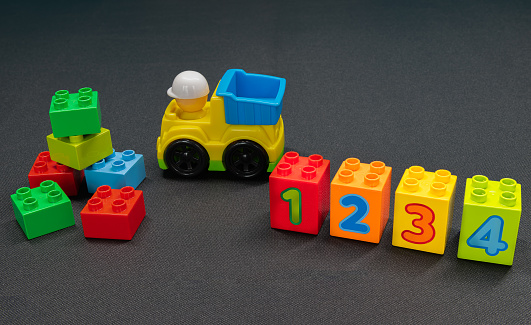 Children's toy truck and building blocks of varying colours and numbers one to four to assist in child'd early development.