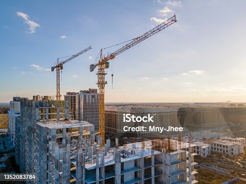 istock Cranes on the construction site surrounded by new real estates. 1352083784