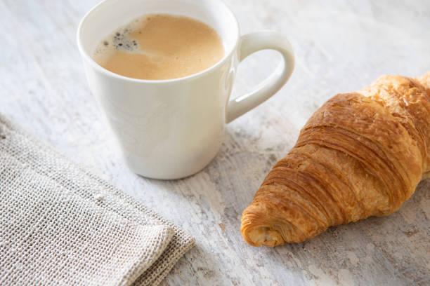 istock Coffee in a white mug with a croissant, viewed from a high angle 1352083824