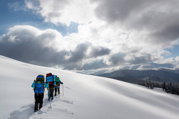 группа туристов исследует зимние горы. - snowshoeing hiking mountain winter стоковые фото и изображения
