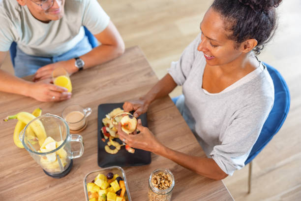 istock Hispanic Mother Cutting The Fruit For Breakfast In The Kitchen 1352085415