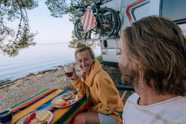 istock Couple enjoy breakfast near their camper-van, beach view 1352085582