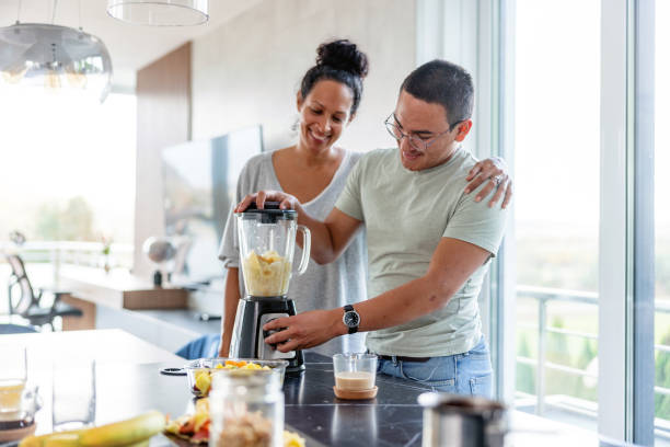 istock Hispanic mother and son making a smoothie with a blender 1352087533