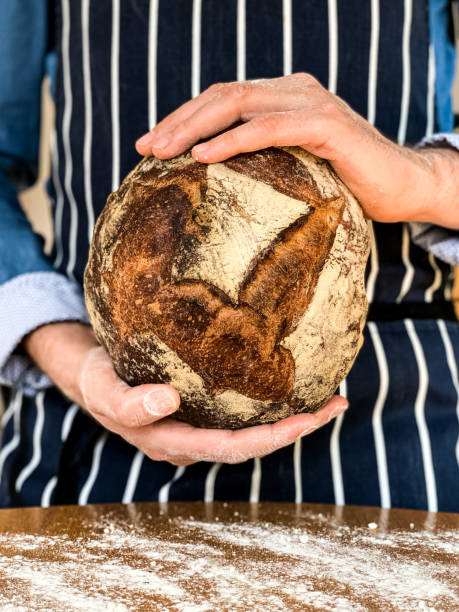 istock Male hands are holding freshly baked sourdough bread 1352087628