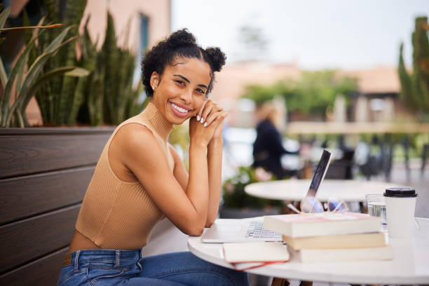 istock Smiling female university student studying outside at a cafe table 1352088104