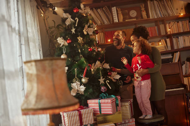 istock Family decorating Christmas tree at home 1352089185