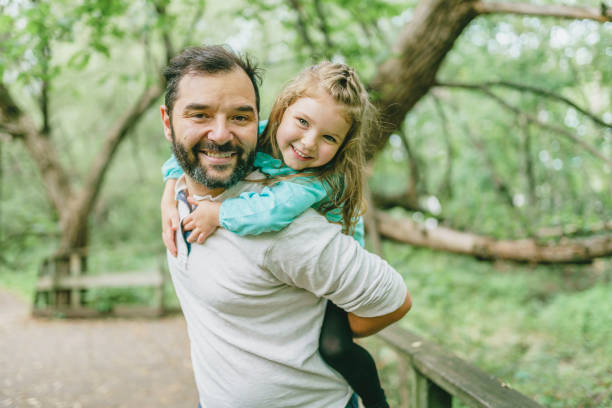 istock nice father having fun in summer forest with his child girl 1352089594