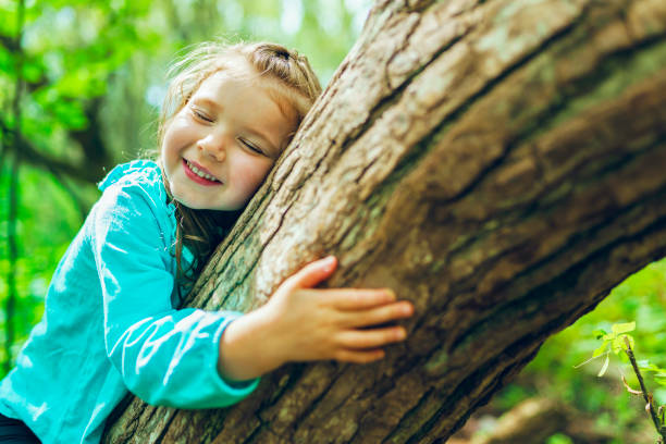 little girl on tree in the summer on nature little girl stock photo