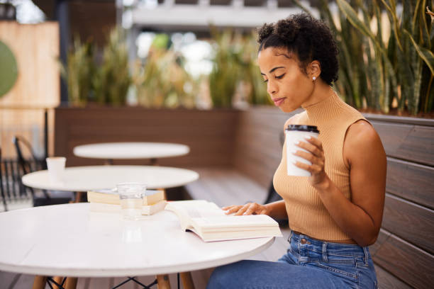 istock Young female university student reading over coffee at a cafe table 1352090200