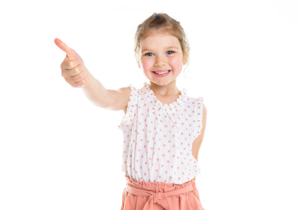 istock cute five year old girl with thumb up on isolated white. 1352091318