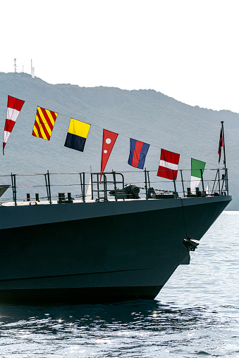 Bow of warship with international sailor flags.