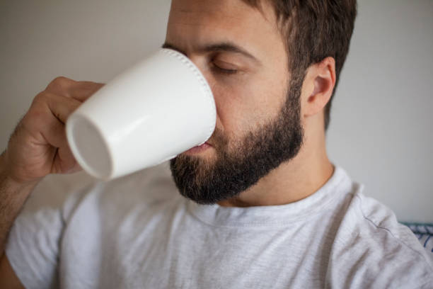 istock Young adult man having a cup of coffee 1352094048