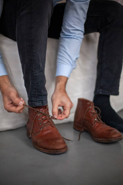 istock Man with leather shoes tying shoelaces 1352094199