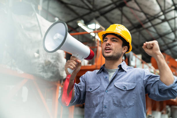 Male blue-collar recycling worker giving speech while using megaphone Medium shot of male blue-collar recycling worker giving speech while using megaphone activist speech stock pictures, royalty-free photos & images