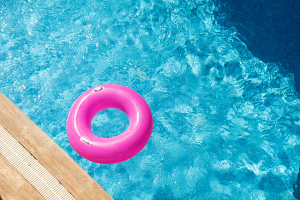 istock Pink inflatable ring in the swimming pool. Refreshing blue water. Top view. Copy space 1352094666