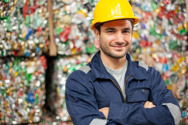 Smiling male recycling plant employee with arms crossed looking at the camera stock photo