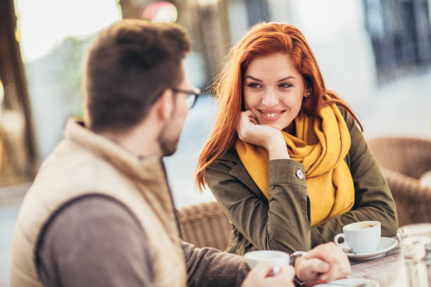 매력적인 젊은 부부 사랑에 앉아 카페 테이블에 야외, 커피를 마시는 - 데이트 뉴스 사진 이미지