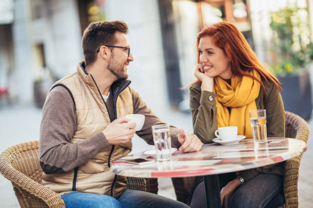 istock Attractive young couple in love sitting at the cafe table outdoors, drinking coffee 1352096034
