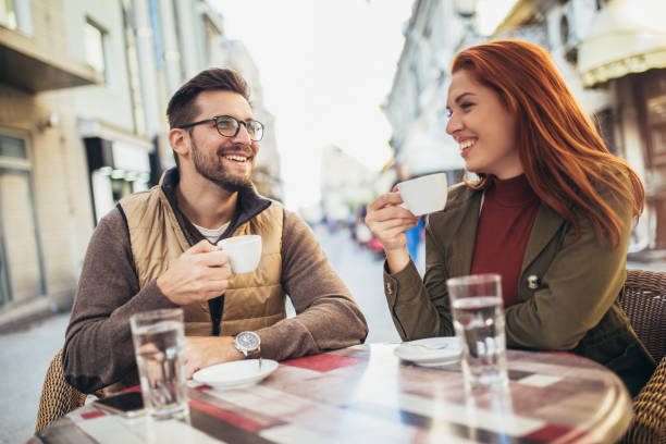 istock Attractive young couple in love sitting at the cafe table outdoors, drinking coffee 1352096063