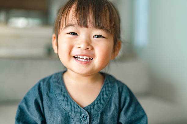 portrait of small girl in living room at home - meisjes stockfoto's en -beelden