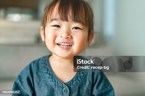 istock Portrait of small girl in living room at home 1352096257